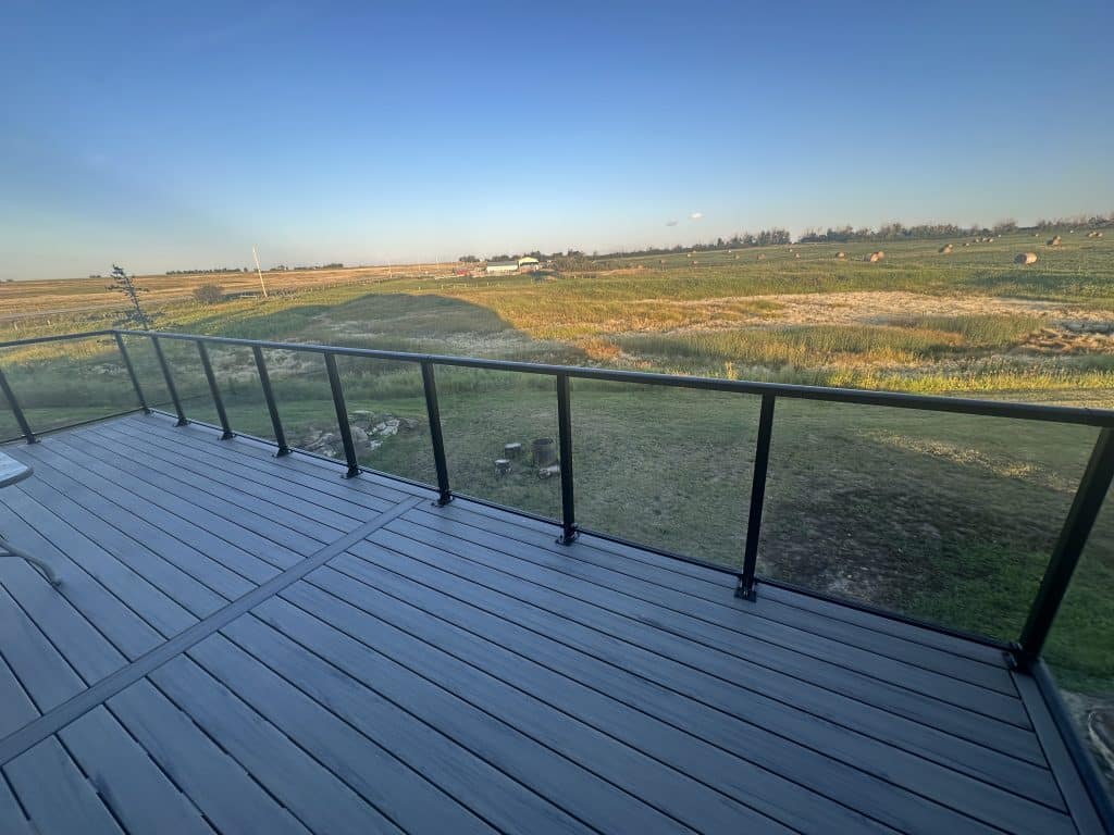 Composite deck with aluminum railing overlooking open landscape built by Pemadale in Calgary