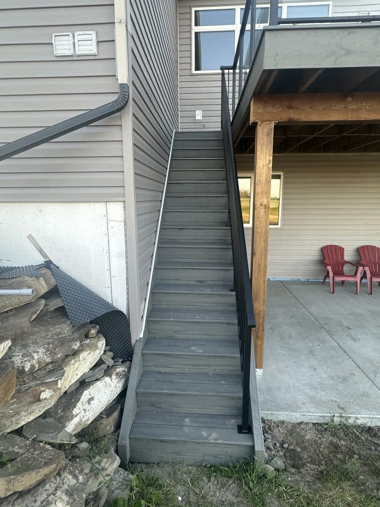 composite deck stairs with black railing from backyard in Strathmore Alberta