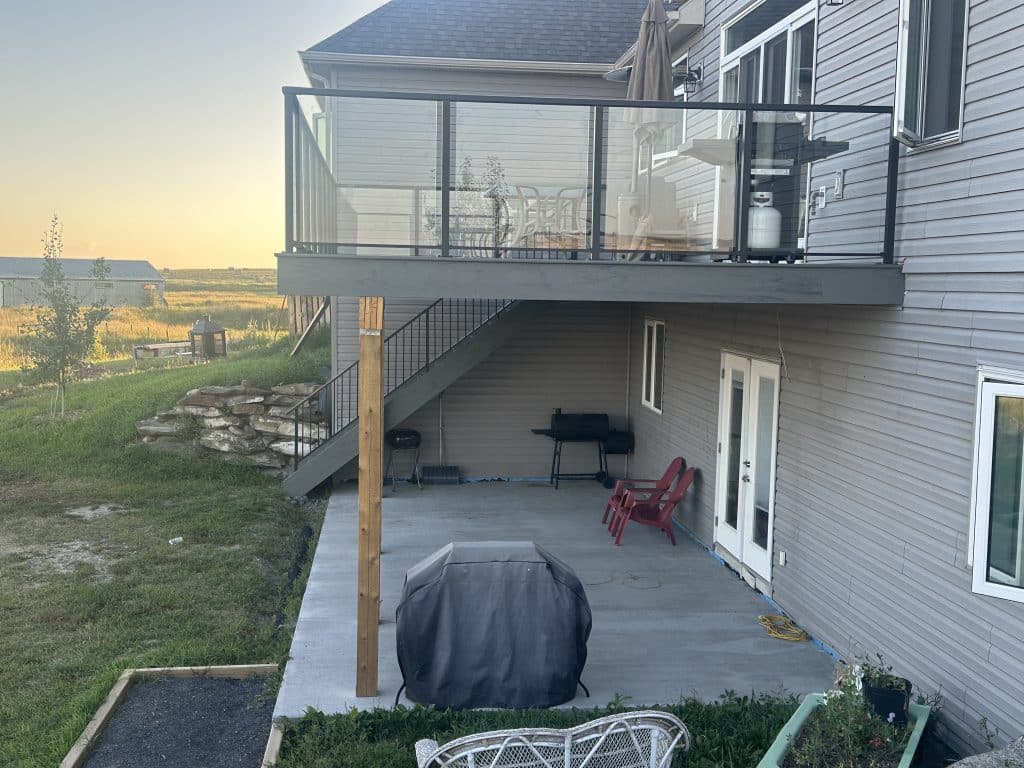 composite walkout deck with covered patio and glass railing in Strathmore Alberta