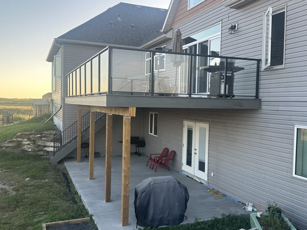 side view of composite walkout deck with glass railing in Strathmore Alberta