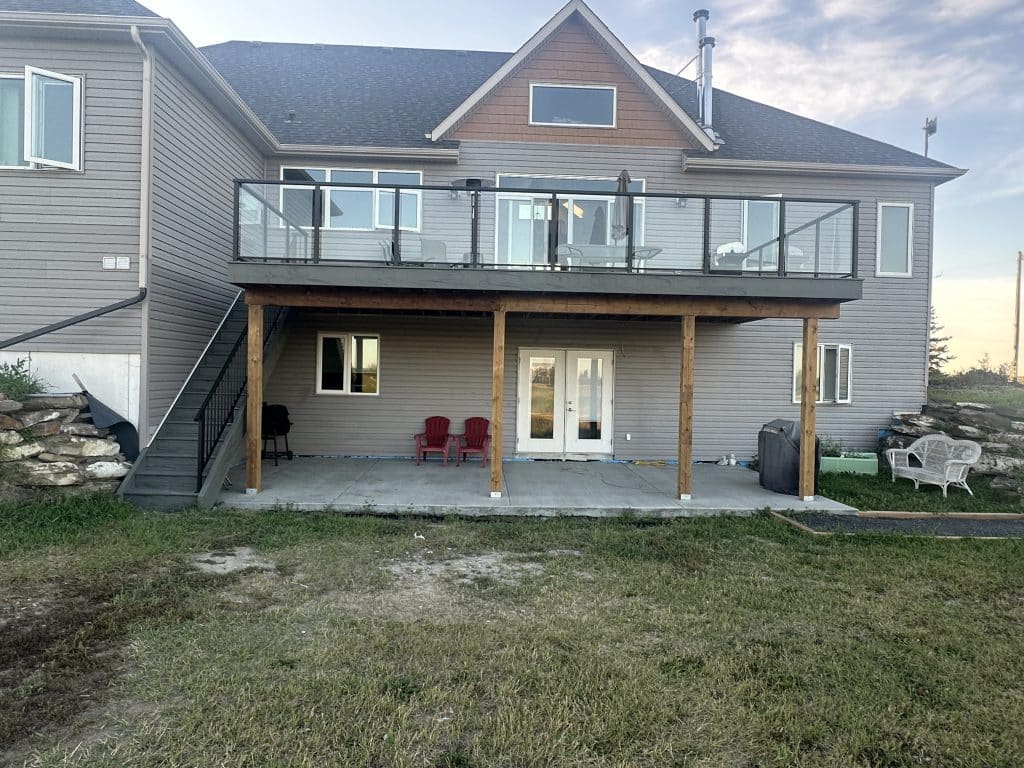 composite walkout deck with glass railing and stairs in Strathmore Alberta
