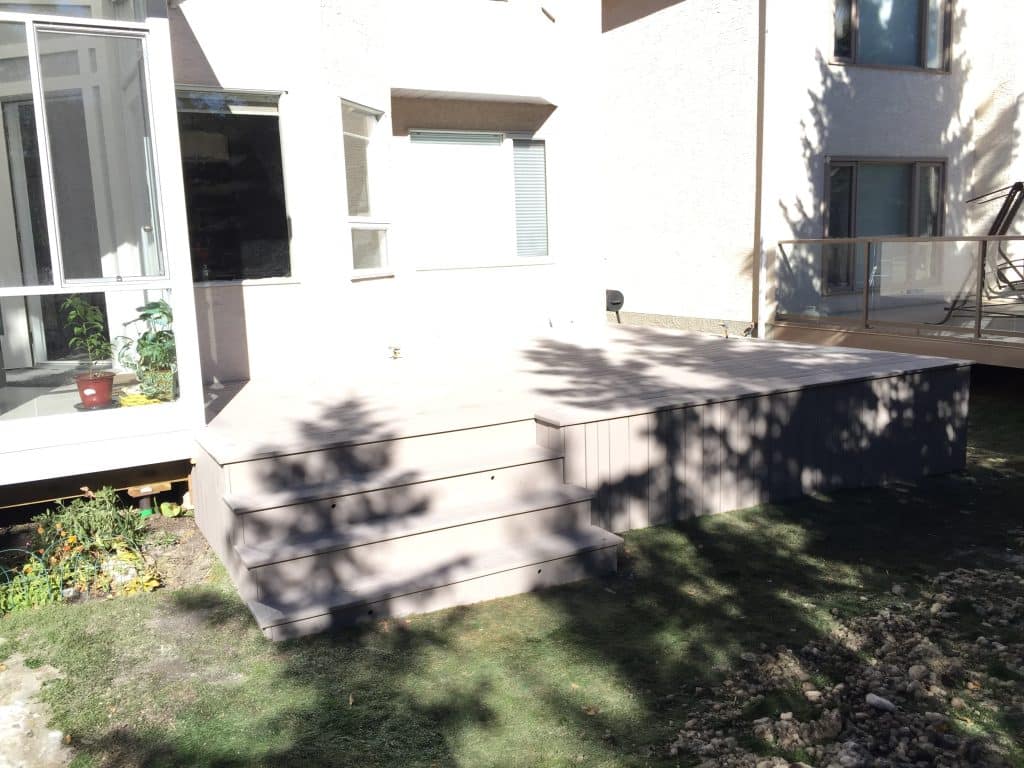 PVC backyard deck with wide steps and finished skirting in the Hamptons Calgary